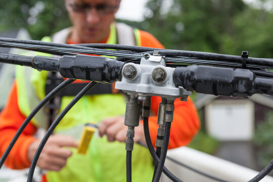 Cable lineman stripping cable for a connection from a bucket truck