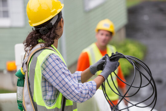 Hispanic female cable lineman looping the cable in bucket lift