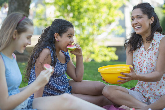 Happy Hispanic family having a picnic in the park