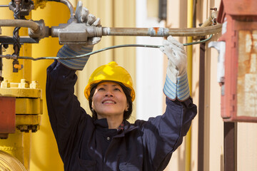 Female power engineer checking fuel line sensors at power plant
