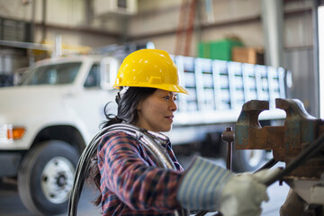 Female power engineer with power cable in service garage