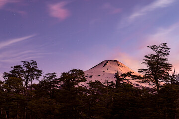 Villarrica volcano glowing in the dark - volcano with illuminated fumaroles, surrounded by stars at...