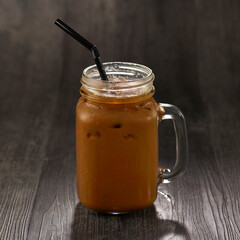 Iced Coffee with straw served in mug isolated on table side view healthy morning drink