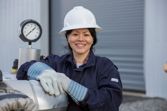 Portrait of female power engineer with pressure sensor at power station
