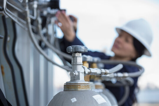 Female power engineer checking injectors at power station