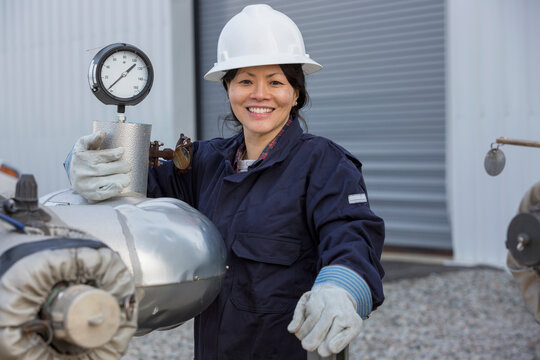 Portrait of female power engineer with pressure sensor at power station