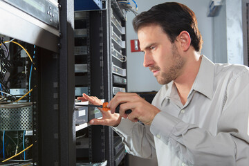Network engineer installing rack mount equipment