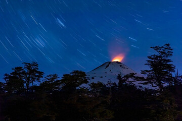Villarrica volcano glowing in the dark - volcano with illuminated fumaroles, surrounded by stars at...