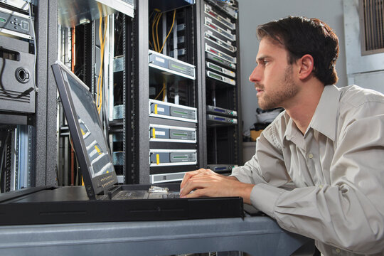 Network engineer in cable server room programming configurations