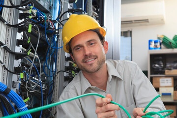 Network engineer pulling cable from reel in network data center