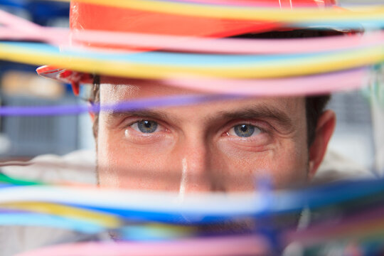 Network engineer examining multi color fiber and copper cables in data center
