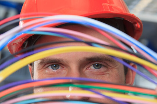 Network engineer examining multi color fiber and copper cables in data center