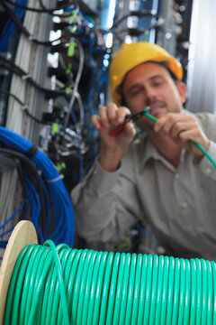 Network engineer cutting cable termination in network data center