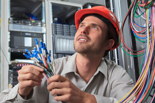Network engineer preparing fiber cables in data center