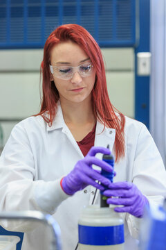 Lab chemist using pipette to gather measured amount of standard solution