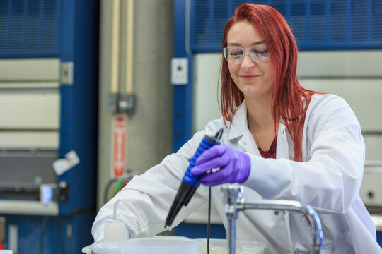 Lab chemist using pipette to gather measured amount of standard solution