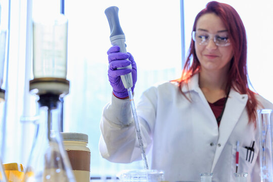 Lab chemist using pipette to gather measured amount of standard solution