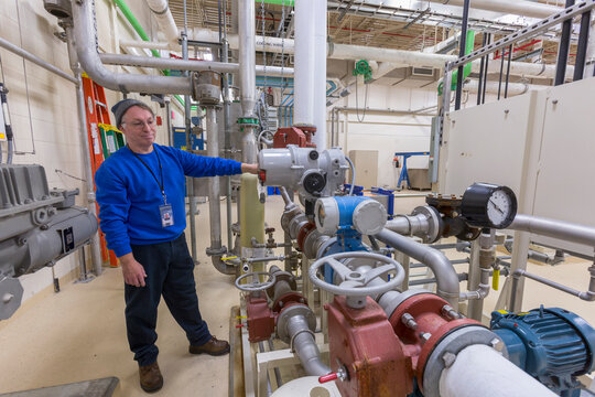 Water treatment plant engineer inspecting chemical treatment equipment