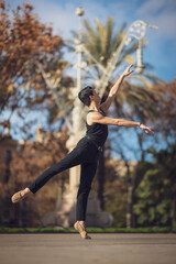 Fototapeta na wymiar Young man dancing classic ballet in the streets of Barcelona with a beautiful background and light