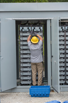 Engineers connecting energy storage batteries for back up power to an electric power plant