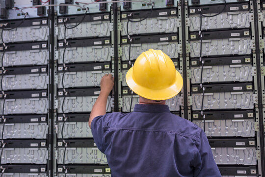 Engineer connecting energy storage batteries for back up power to an electric power plant