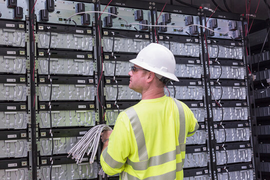 Engineer connecting energy storage batteries for back up power to an electric power plant