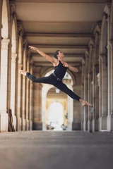 Young man dancing classic ballet in the streets of Barcelona with a beautiful background and light © Joel