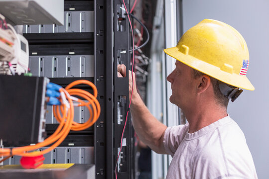 Engineer connecting energy storage batteries for back up power to an electric power plant