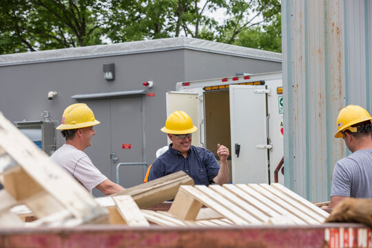 Engineers putting pallets into a dumpster