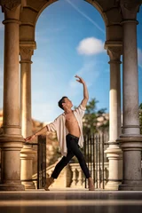 Young man dancing classic ballet in the streets of Barcelona with a beautiful background and light © Joel