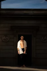 Young man posing with a unbuttoned shirt while sunlight is chasing him © Joel