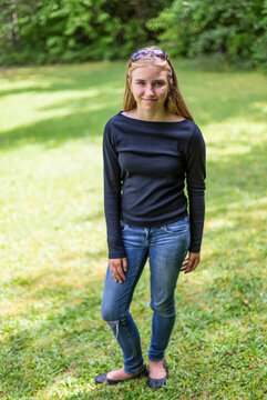 Portrait of a pre-teen girl standing on grass in a  park; Salmon Arm, British Columbia, Canada