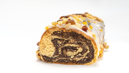 Obraz na płótnie Canvas Isolated Christmas strudel Makowiec with poppy seeds,traditional polish festive cake covered with sugar icing, walnuts, dried fruits on white background. Horizontal