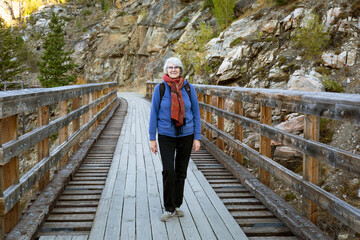 A woman stands on a restored train trestle bridge in Myra Canyon; Kelowna, British Columbia, Canada