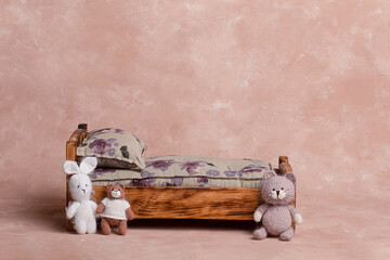 background texture for baby with wooden bed and mattress with flowers. Celebratory background design for birthday celebration. basket for a newborn photo shoot.plush toys near small children's bed