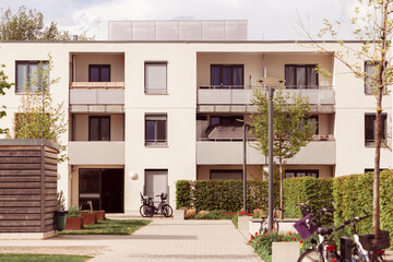 Fototapeta na wymiar European Residential complex of Apartment Buildings in Germany. Outdoor facilities. Eco-friendly living in Eco city. Modern block of Flats. Courtyard, Bikes Road, Trees, Terrace