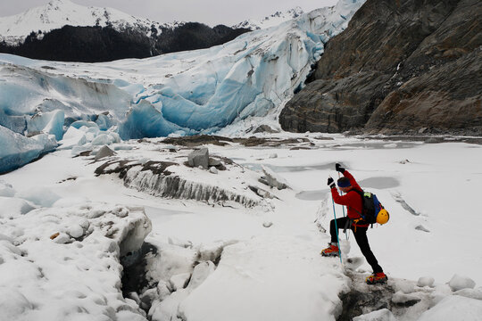 A hiker treks over cracking ice fissures of Mendenhall Glacier, Alaska, USA