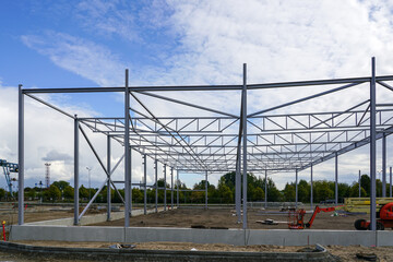 Fototapeta premium Assembled steel framework of new modern industrial building with foundation concrete panel border