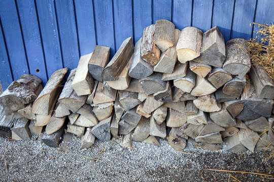 preparation of frewood for the winter. Woodpile against a blue wall.