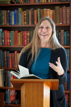 Portrait of a mature woman reading at a podium; Ottawa, Ontario, Canada