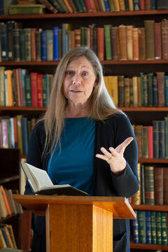 Portrait of a mature woman reading at a podium; Ottawa, Ontario, Canada