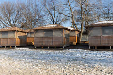 Wooden gazebos wrapped in foil in winter. Insulation of gazebos in winter