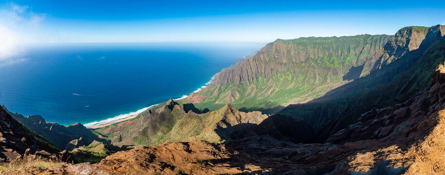 Panoramic image of a sunlit rugged landscape and ocean along the Na Pali Coast on the island of Kauai, Hawaii, USA; Kauai, Hawaii, United States of America