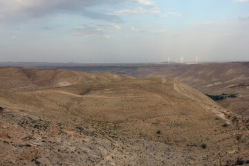 Desert landscape view of sunny rocky cliff with wind turbines in view taken from Shobak Castle, Jordan