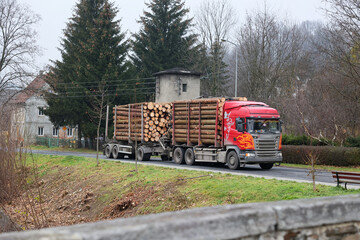 Ciężarówka z przyczepą przewozi drewno z lasu do fabryki. - obrazy, fototapety, plakaty