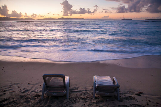 Beach chairs look out to the sunset on a caribbean island; Virgin Gorda, British Virgin Islands