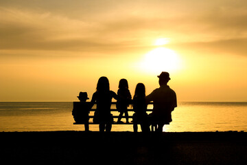 Fototapeta na wymiar A happy family in nature by the sea on a trip silhouette