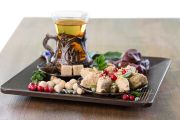 Bronze plate with arabian sweets and tea. Ramadan Kareem.