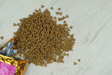 Dry fodder for cats and dogs in package on a wooden background. Top view. Copy space.