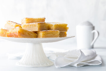 Fototapeta na wymiar Delicious lemon squares on a pedestal stand sprinkled with powdered sugar.